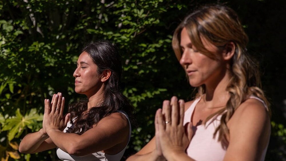 Two women meditating outdoors