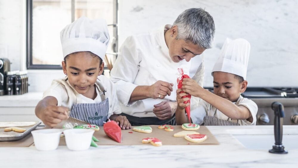 Chef and kids making holiday decorative cookies